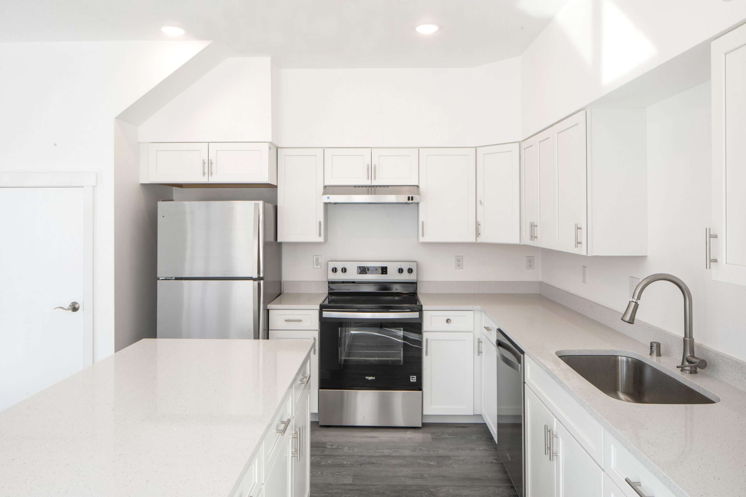 Kitchen including range, dishwasher, and refrigerator.